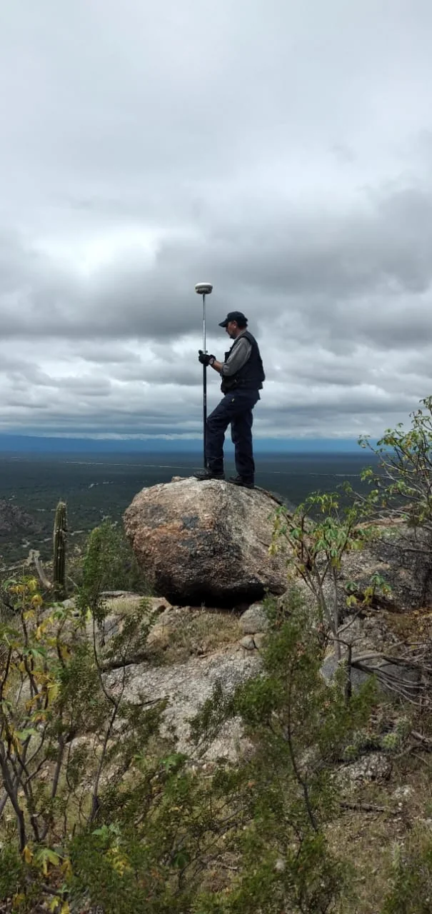 Técnico con GPS en cima de roca - prospección arqueológica